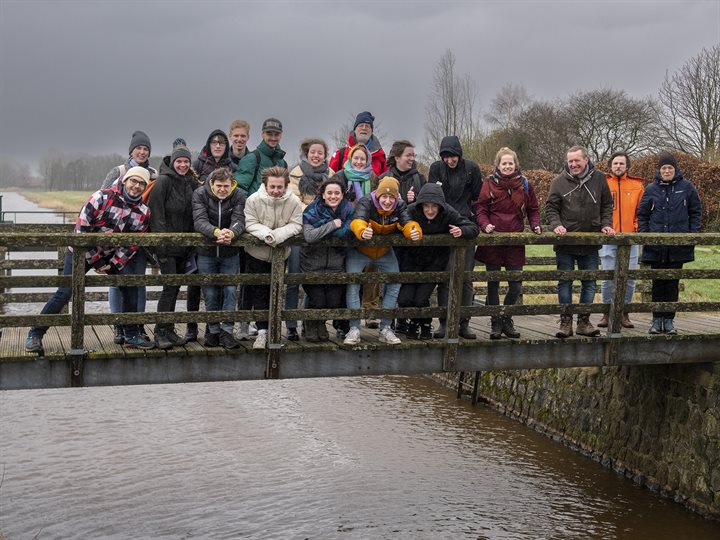 Een groep studenten staat op een brug over het Voorste Diep